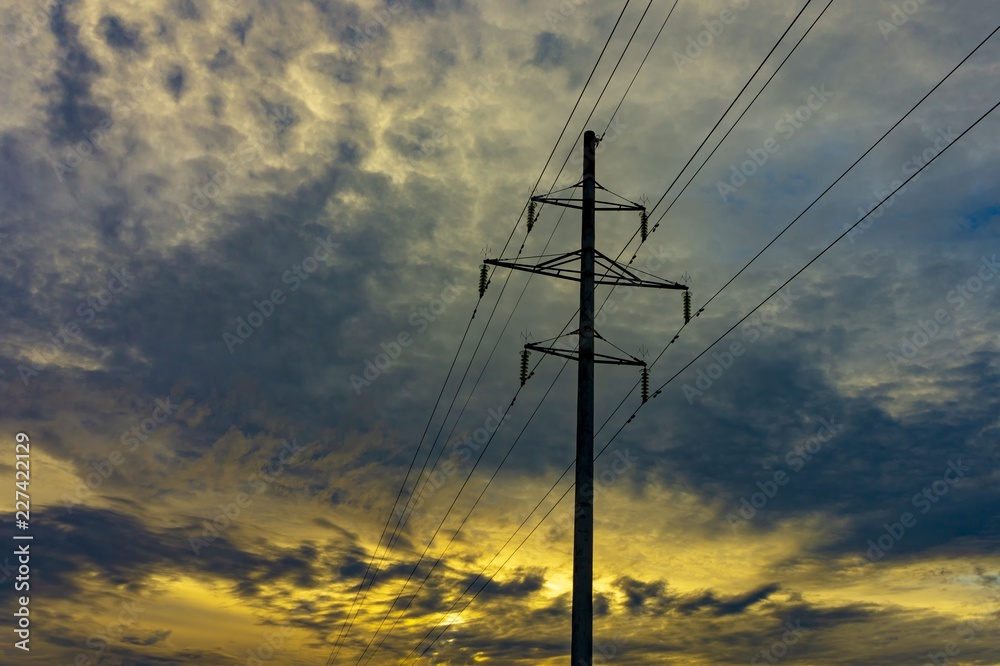 Electricity power lines against a sunset sky