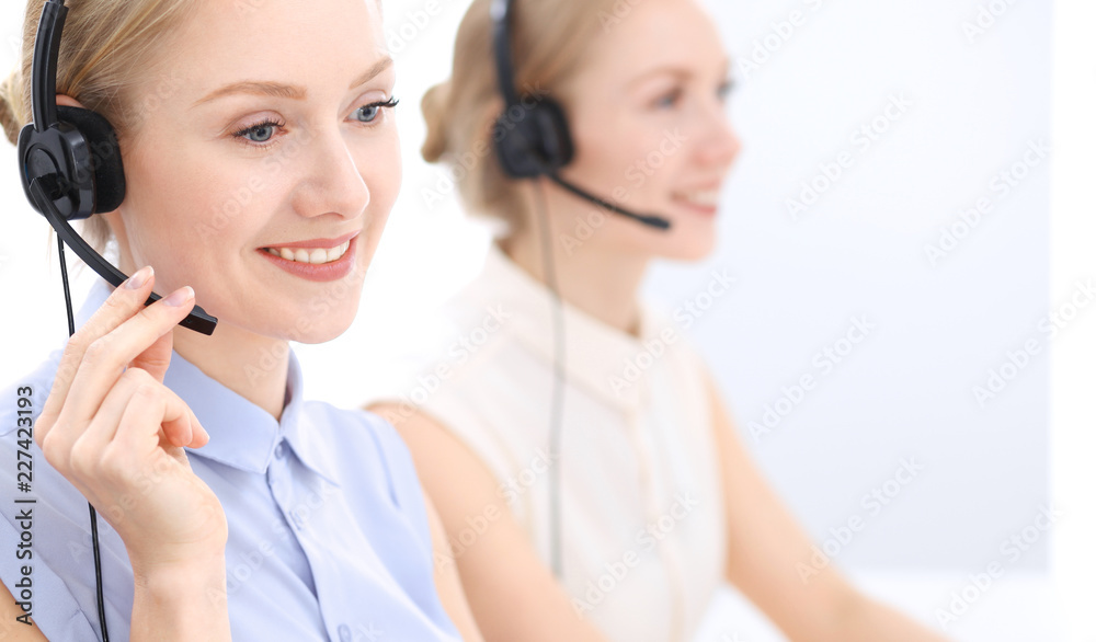 Bright call center office. Two blonde women in a headset Bright call center office. Two blonde women in a headset