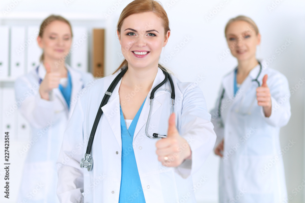 Groupe of medicine doctors show OK sign with thumb up. Success and high level service in health care, best treatment and customer loyalty and physical concept. Copy space for advertisement Groupe of medicine doctors show OK sign with thumb up. Success and high level service in health care, best treatment and customer loyalty and physical concept. Copy space for advertisement