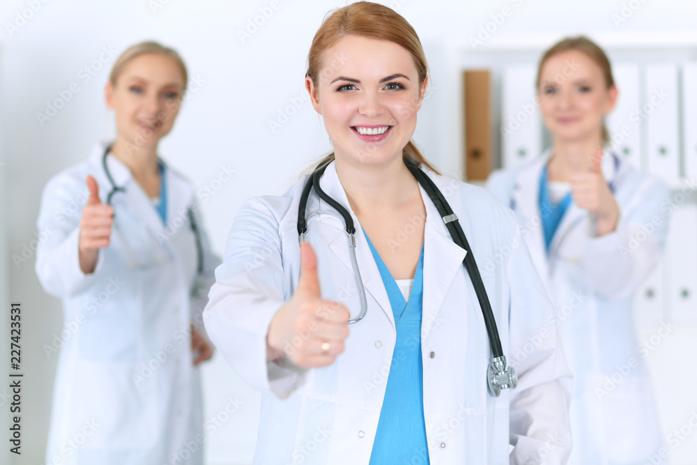 Groupe of medicine doctors show OK sign with thumb up. Success and high level service in health care, best treatment and customer loyalty and physical concept. Copy space for advertisement Groupe of medicine doctors show OK sign with thumb up. Success and high level service in health care, best treatment and customer loyalty and physical concept. Copy space for advertisement