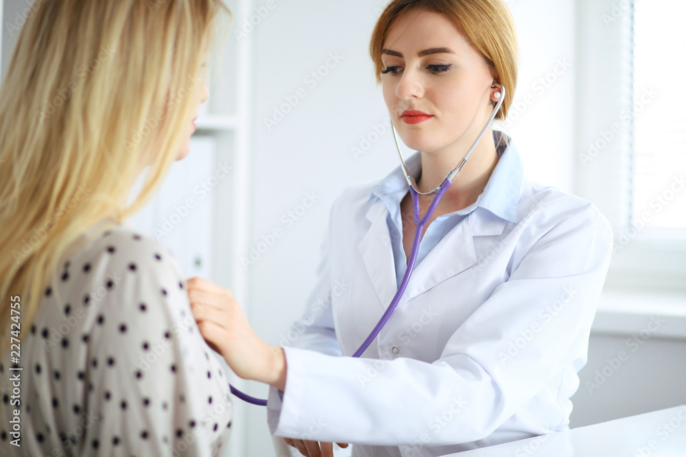 Doctor examines a patient with a stethoscope Doctor examines a patient with a stethoscope