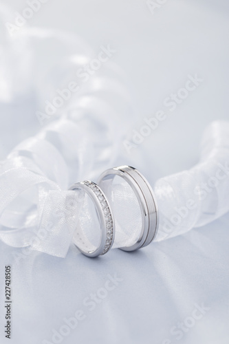 Pair of white gold wedding rings with diamonds in womens ring and matte surface in mens ring