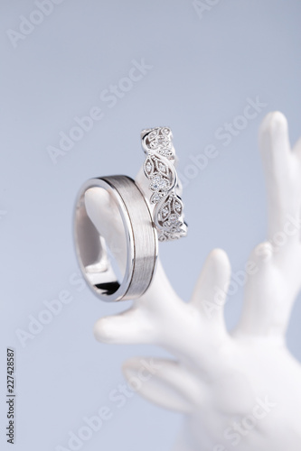 Pair of silver wedding rings with diamonds on blue background photo