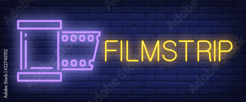 Filmstrip neon sign. Peace of film strip on brick wall background. Vector illustration in neon style for movie making, cinema, tape editing