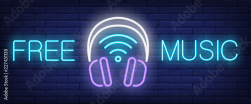 Free music neon sign. Headphones with wifi symbol on brick wall background. Vector illustration in neon style for internet and free service
