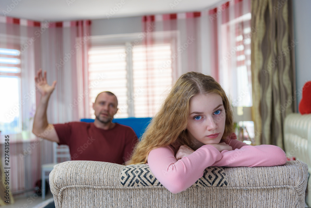 Family problems, family relations father and teen daughter in a room on the sofa. Family problems, family relations father and teen daughter in a room on the sofa.