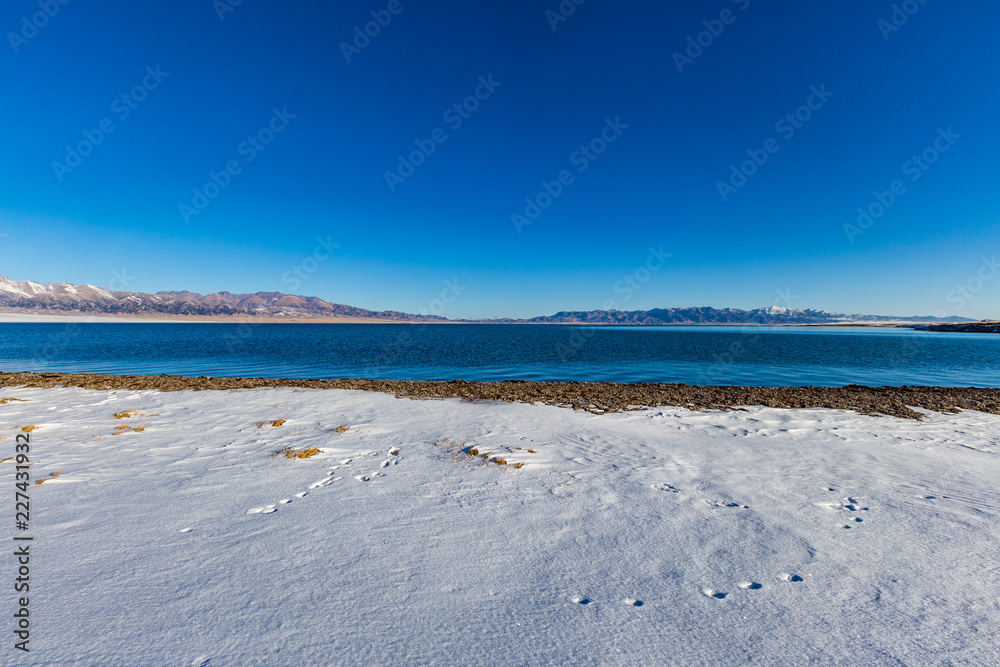 The frozen Sailimu lake with snow mountain background at Yili, Xinjiang of China The frozen Sailimu lake with snow mountain background at Yili, Xinjiang of China