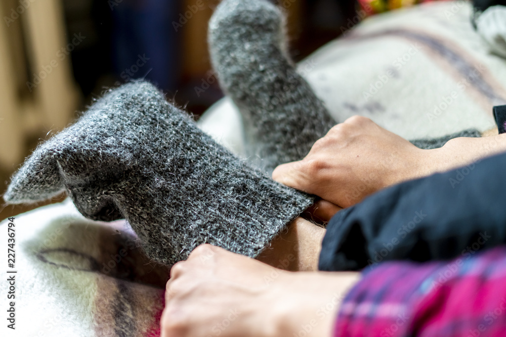 close up person wearing and put on warm wool socks on cold winter day f close up person wearing and put on warm wool socks on cold winter day f