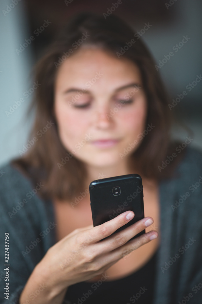 Young attractive woman in blur texting on her mobile phone Young attractive woman in blur texting on her mobile phone