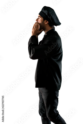 Chef man In black uniform shouting on isolated white background © luismolinero