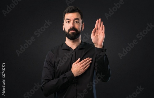 Konstfotografi Handsome man with beard making an oath on black background