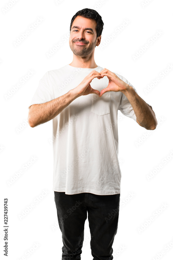 Young man with white shirt making heart symbol by hands. Being in love on isolated white background