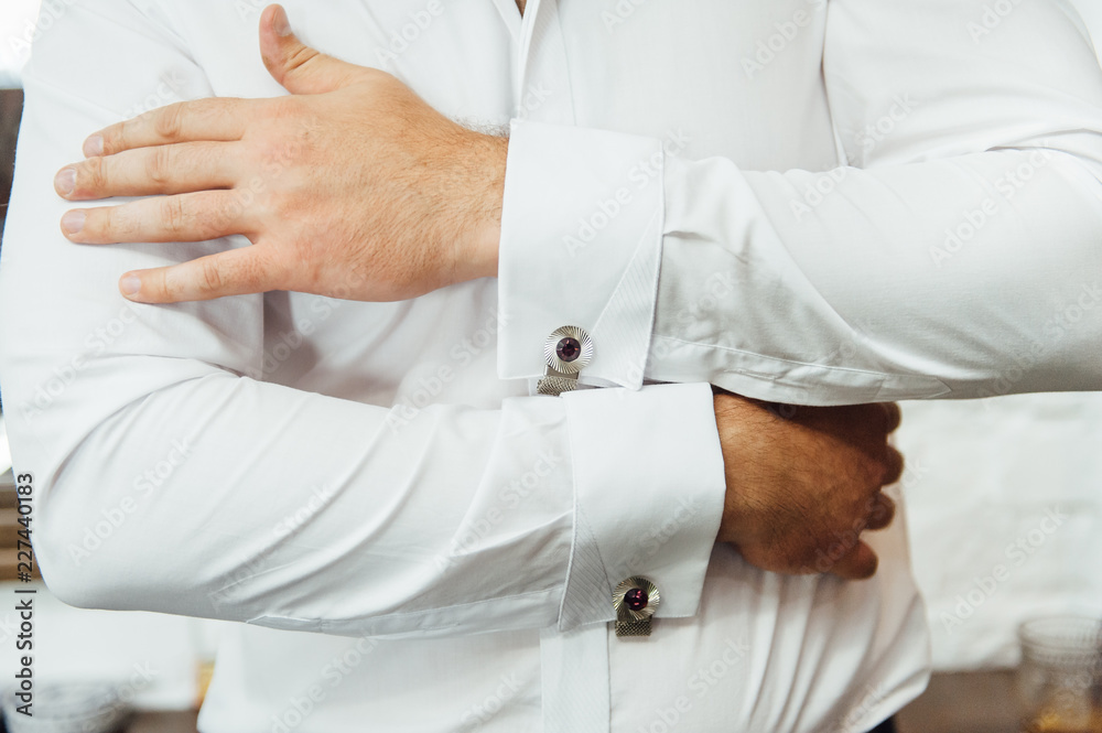 Close-up of a man in a tux fixing his vintage cufflink. groom bow tie cufflinks