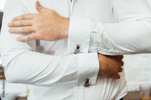 Close-up of a man in a tux fixing his vintage cufflink. groom bow tie cufflinks