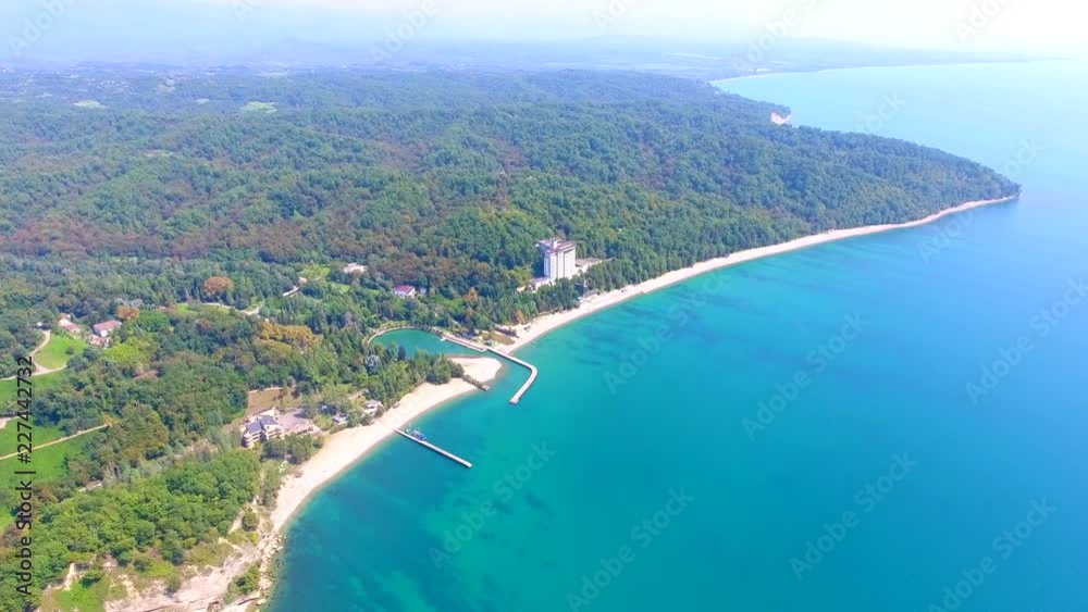 Amazing sand beach and health resort, ship Parking, tropical coral reef lagoon towards, beautiful green mountains on Abkhazia, Pitsunda. Aerial view flying over rocky mountain view Black sea. Amazing sand beach and health resort, ship Parking, tropical coral reef lagoon towards, beautiful green mountains on Abkhazia, Pitsunda. Aerial view flying over rocky mountain view Black sea.