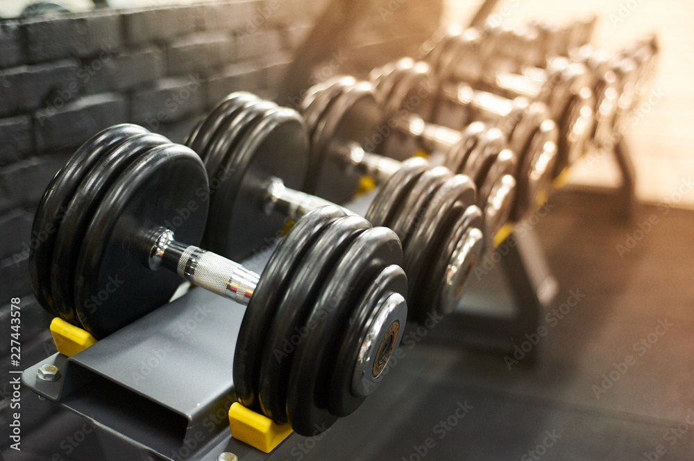 dumbbells row in a gym. sport sunny background dumbbells row in a gym. sport sunny background