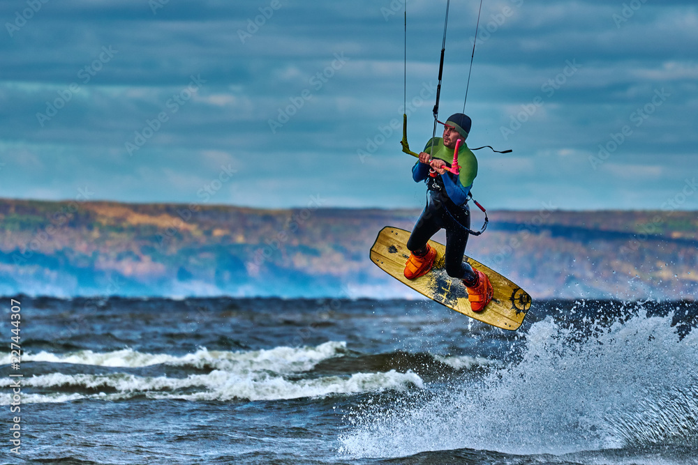 Naklejka premium A male kiter jumps over a large lake. Close-up.