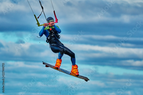 A male kiter jumps over a large lake. Close-up.