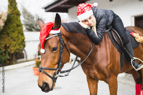 Beautiful young woman enjoying with her horse in winter holidays.