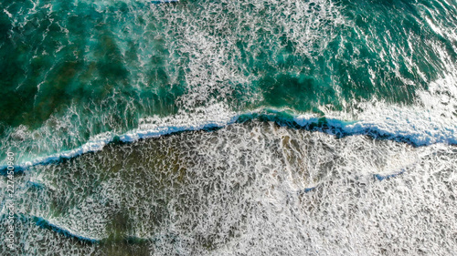 Aerial downward view of sea waves on a beautiful sunset © jovannig