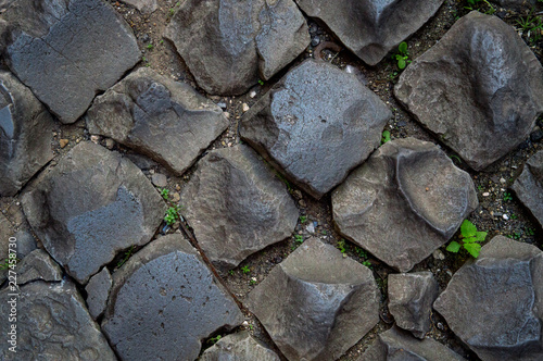 Close up, flat lay. The texture of the old road. Gray cobblestones of paving stones, sometimes blackened by time.