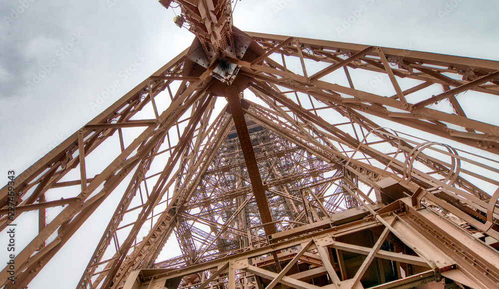Eiffel Tower top structure, skyward view on a cloudy day - Paris