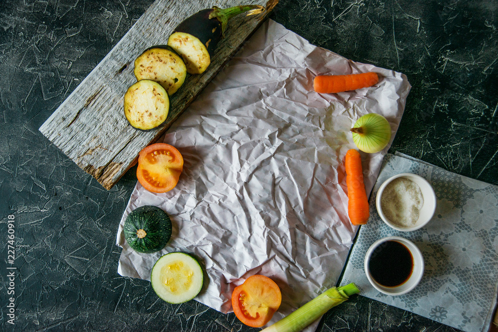Healthy and healthy food: grilled vegetables and men's hand with fork in the frame, zucchini, eggplant, tomato, onion cooked on fire, on a dark background