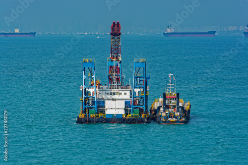 Grab Dredger - revolving crane, fitted with a grab, placed on a hopper vessel or pontoon. Singapore Strait. © Igor Groshev