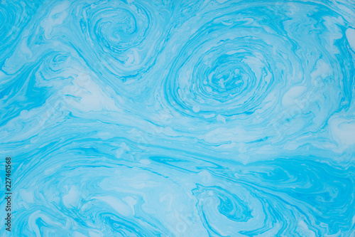 Abstract blue marble background. Stains of paint on the water.