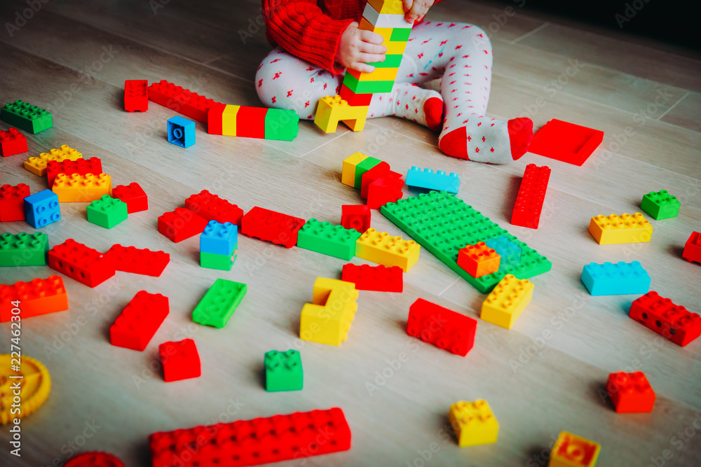 little baby playing with colorful plastic blocks