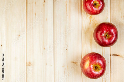 Minimal style, red apples on wooden background with copyspace, autumn, seasonal organic farm food and harvest concept