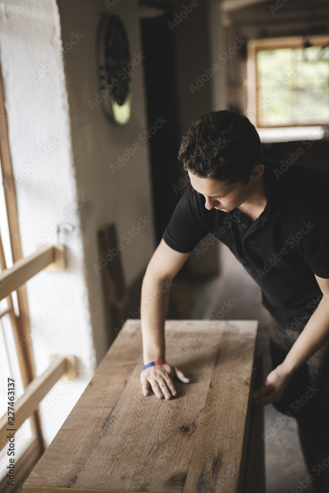 Carpenter in workshop testing chest of drawers Carpenter in workshop testing chest of drawers