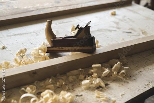 Plane on piece of wood in workshop