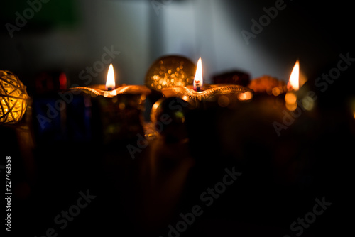 Beautiful diwali diyas at night with flowers, lighting series and gifts, moody background