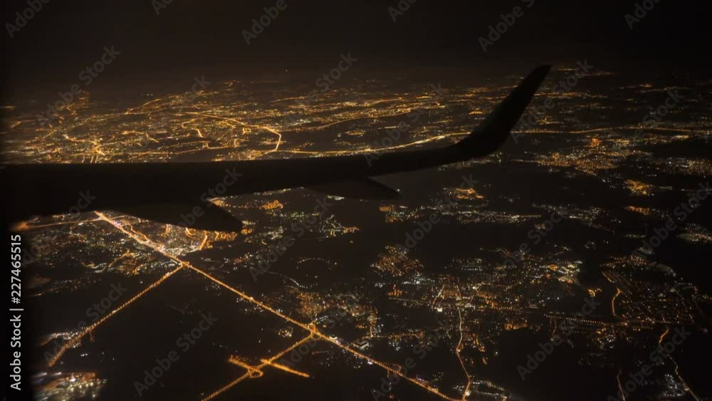 View from airplane with wing. flying at night over city light and street