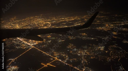 View from airplane with wing. flying at night over city light and street