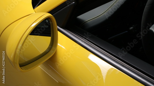 Specchietto di una automobile tedesca dalla carrozzeria giallo brillante
