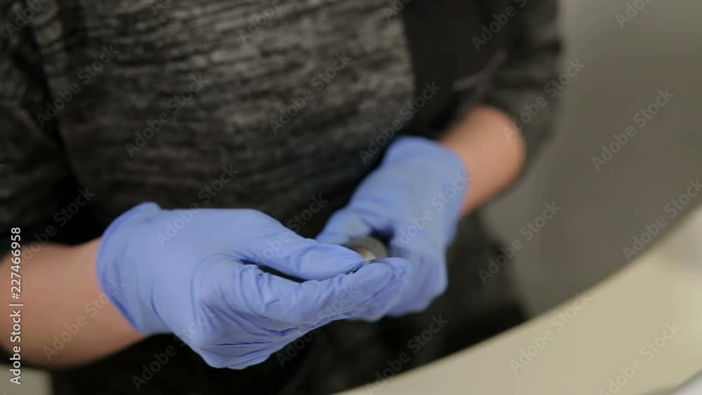 Master of the manicure changes attachments on an electric typewriter for a hardware manicure, close-up. Preparation for manicure in the beauty salon. A manicurist with gloves is getting ready for work Master of the manicure changes attachments on an electric typewriter for a hardware manicure, close-up. Preparation for manicure in the beauty salon. A manicurist with gloves is getting ready for work