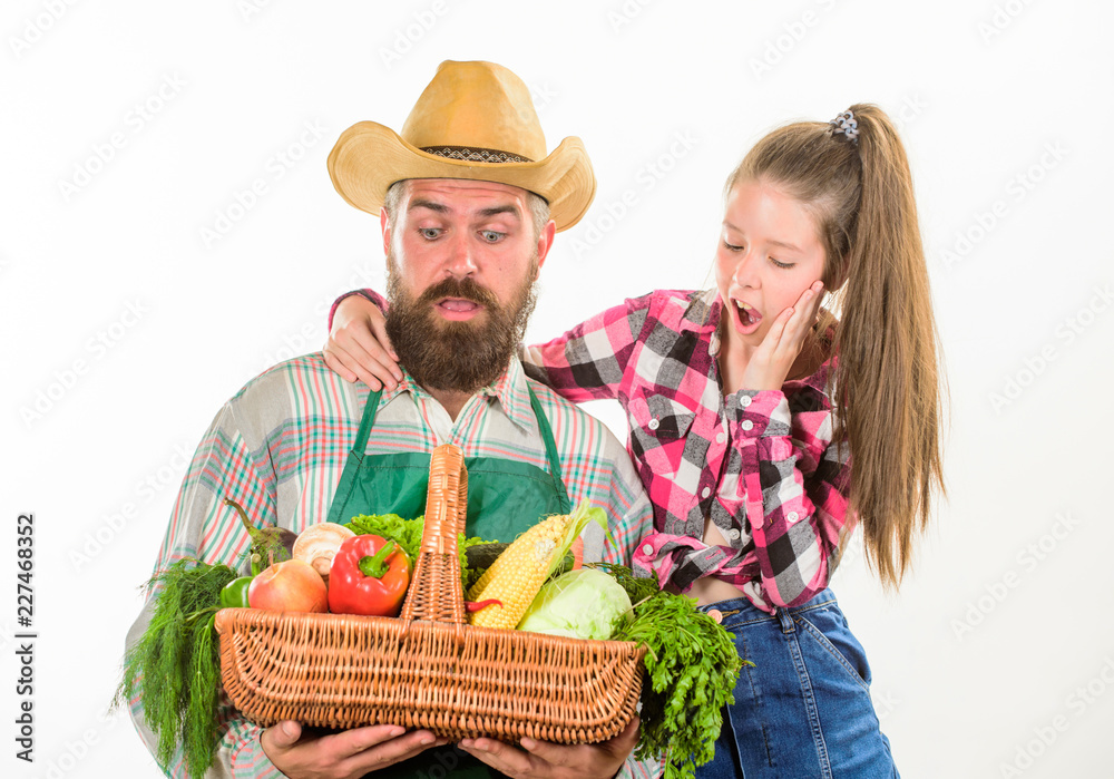 Family farm organic vegetables. Father farmer or gardener with daughter hold basket harvest vegetables. Man bearded rustic farmer with kid. Farmers family homegrown harvest. Gardening and harvesting