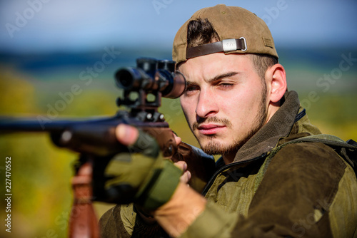 Hunting weapon gun or rifle. Man hunter aiming rifle nature background. Hunting skills and weapon equipment. Hunting target. Looking at target through sniper scope. Guy hunting nature environment