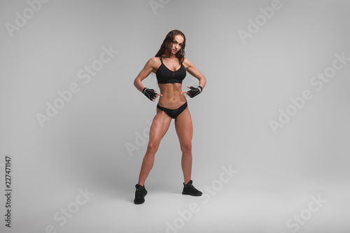 Confident muscular woman showing abs