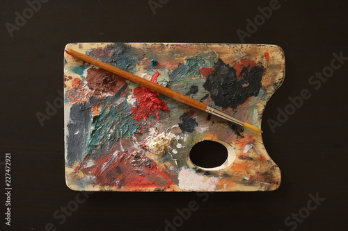 Composizione di oggetti artistici, tavolozza, colori ad olio e pennello, su sfondo nero photo