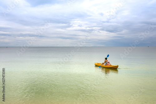 Asian mom kayaking with daughter at sea on sunshine day © Soonthorn Kittikarn