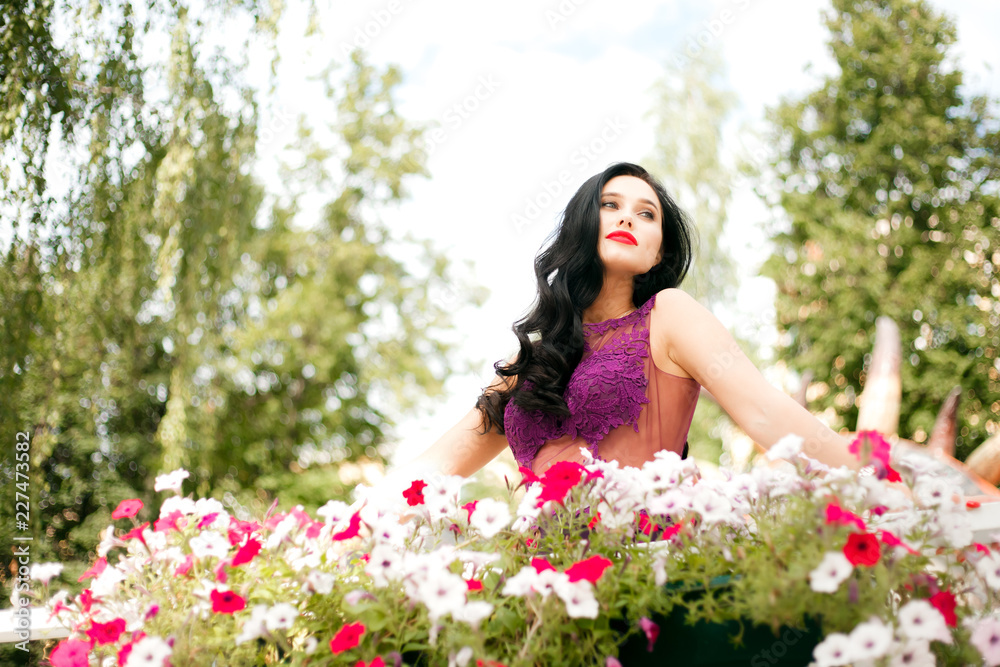 A woman on a background of flowers, in a beautiful dress. The concept of femininity and beauty. A woman on a background of flowers, in a beautiful dress. The concept of femininity and beauty.