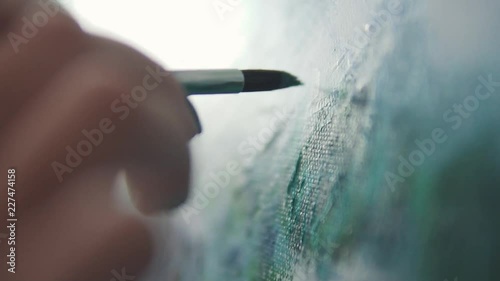 the painter makes a brush stroke on the picture. closeup paint brush