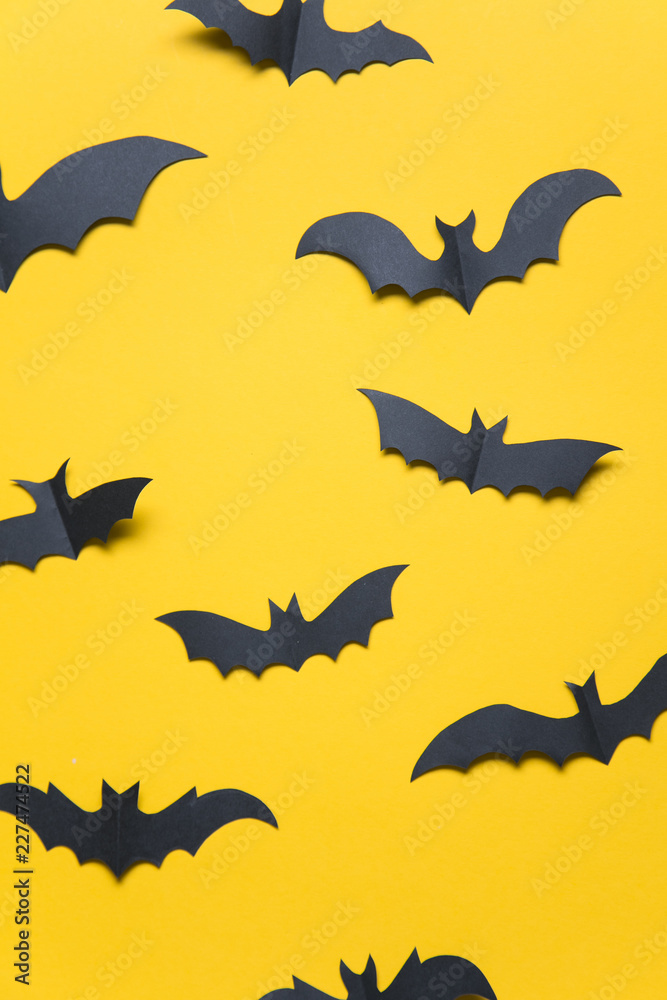 Fototapeta premium Halloween paper vampire bat decorations on an orange background.