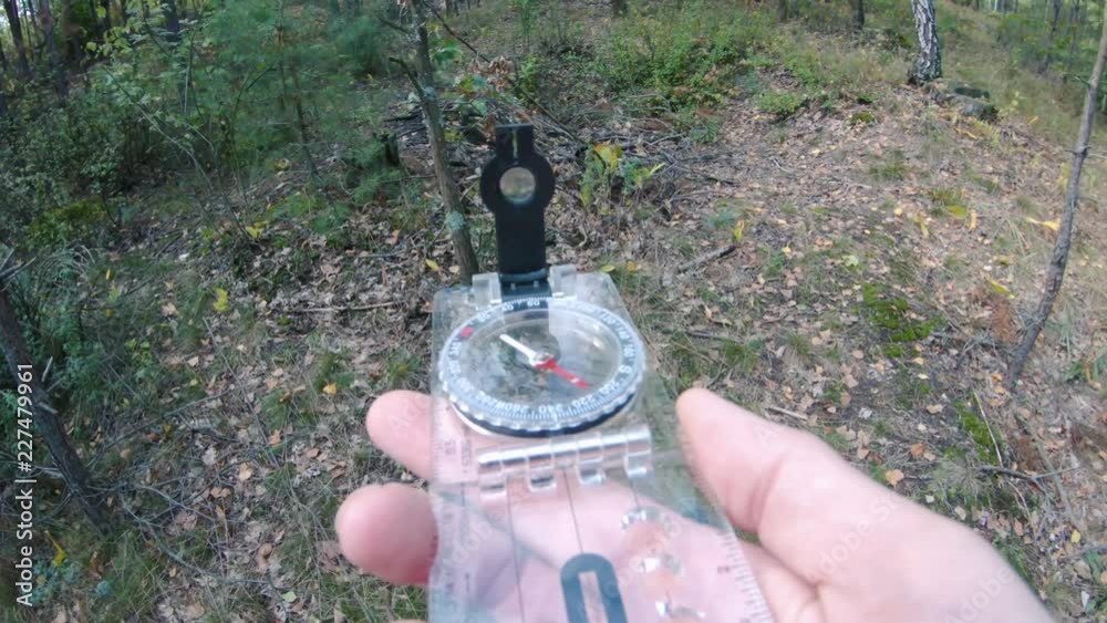 man's hand with a compass. orienteering in the forest