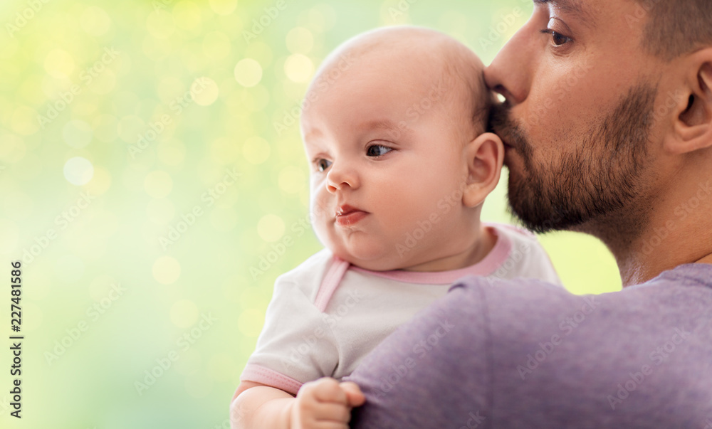 family, parenthood and people concept - close up of father kissing little baby daughter over festive lights background family, parenthood and people concept - close up of father kissing little baby daughter over festive lights background