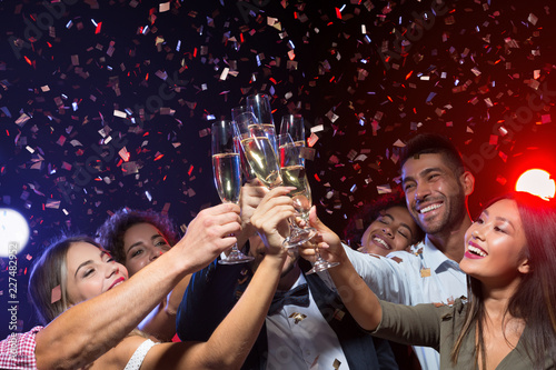 Party with friends. Group of cheerful people carrying champagne flutes