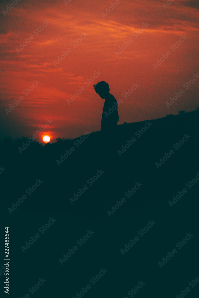 Fototapeta premium Boy looking at sunset